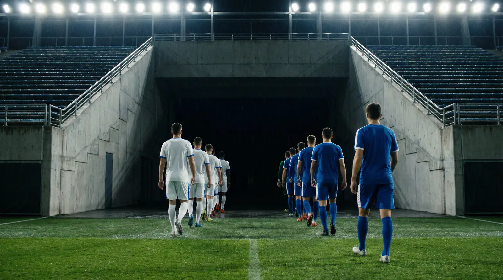 Jugadores de fútbol caminando hacia el túnel de vestuarios durante el descanso del partido